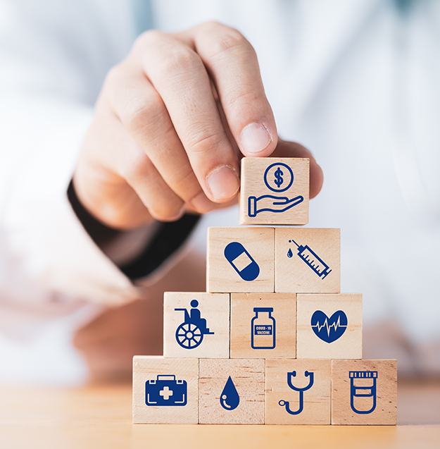 A medical professional's hand arranging small wooden blocks displaying medical symbols